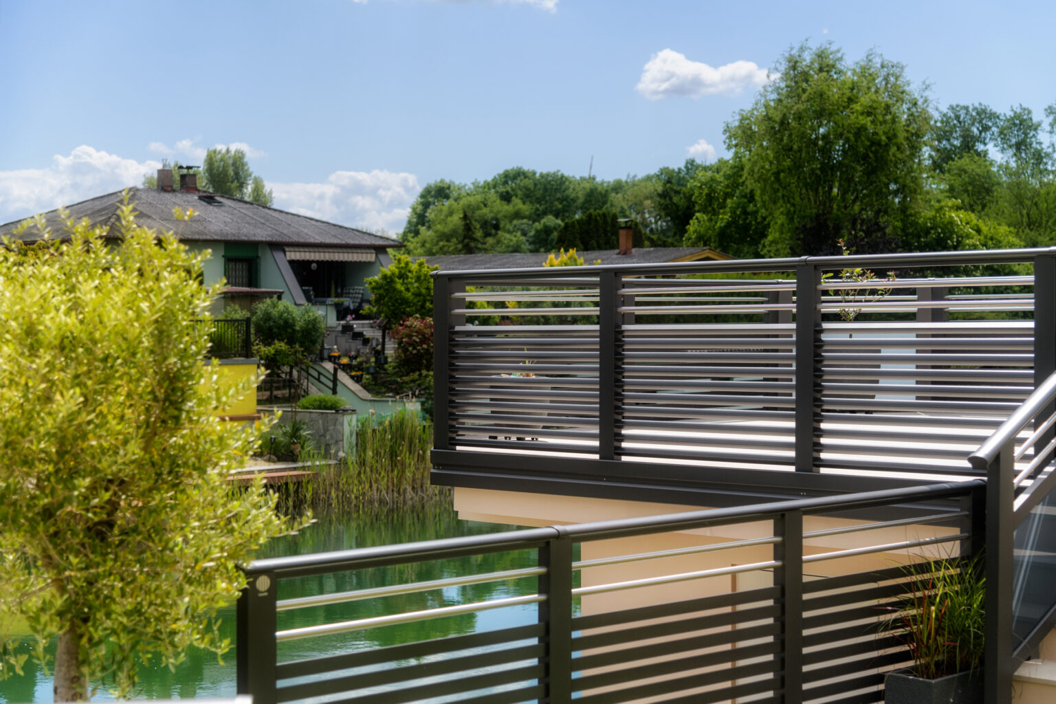 Alubalkon Barcelona mit Edelstahlstreben und Dreieckssprossen am See